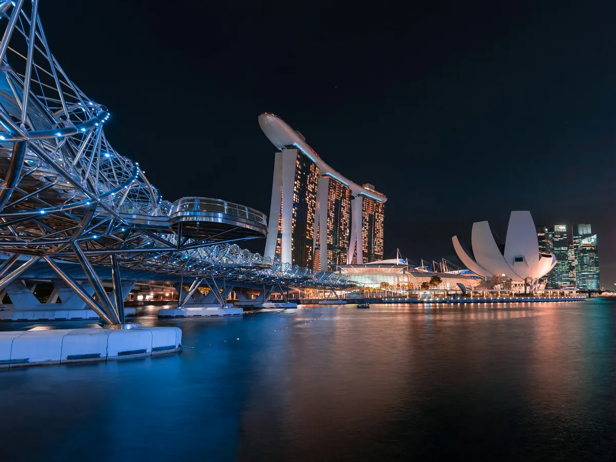 The Helix Bridge and Marina Bay Sands at night, with the ArtScience Museum and the CBD skyline behind, Singapore